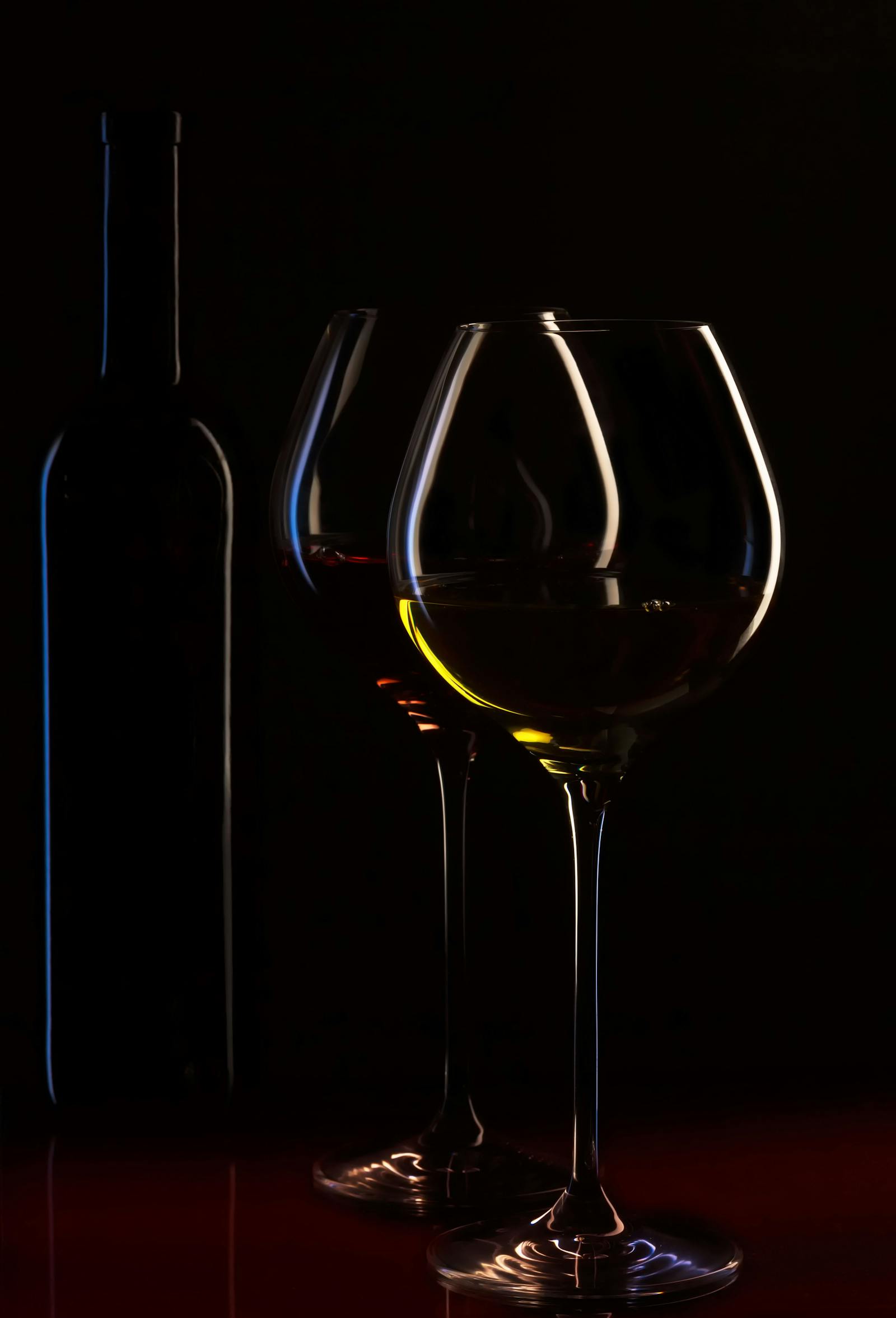 Wine bottles and glasses in intimate lighting